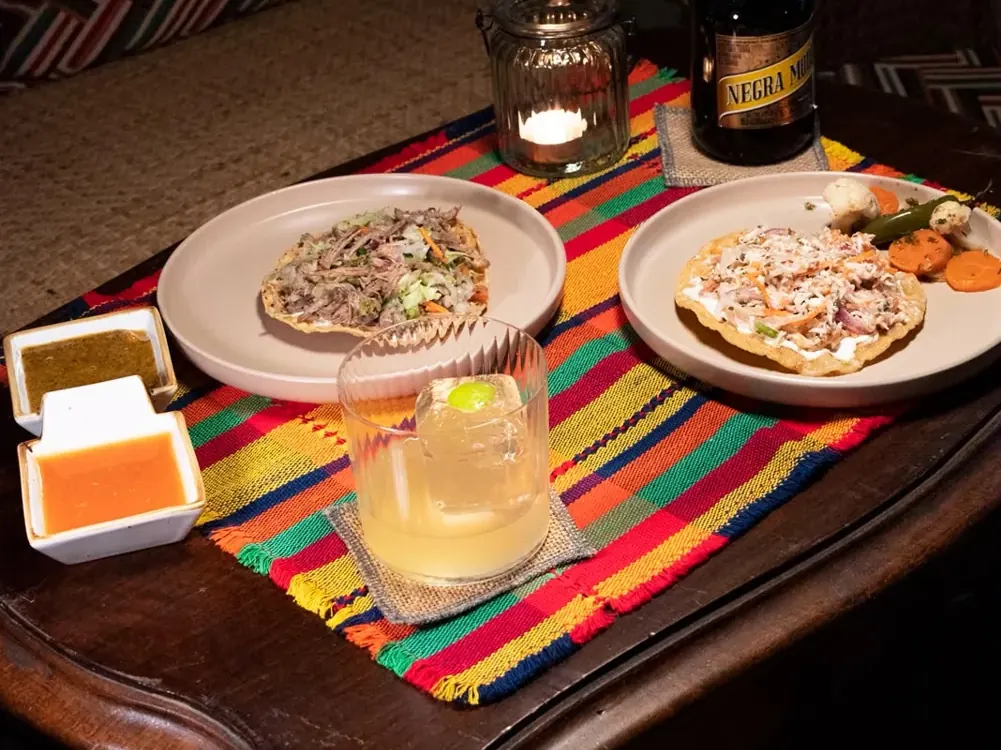 Tostadas, salsas y una copa sobre un mantel mexicano en La Soldadera